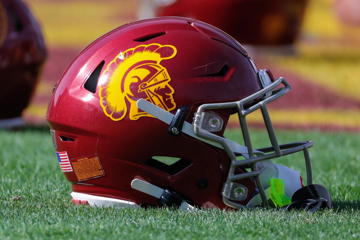 USC football helmet on the grass in a stadium.