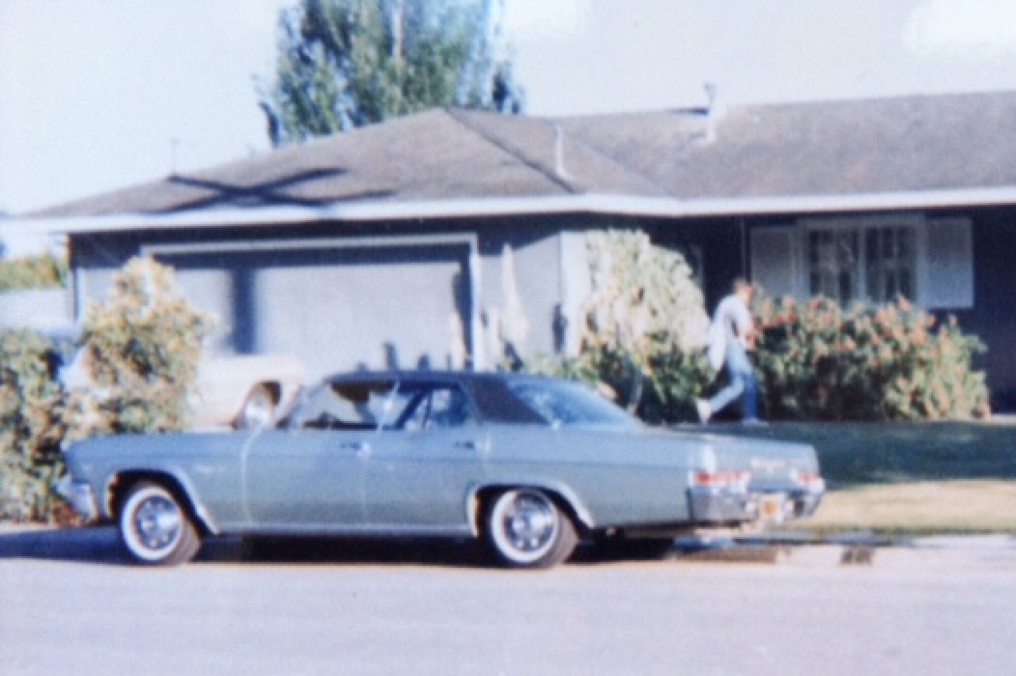 A blue 1966 Chevy Impala parked on the street