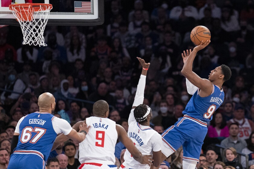 El base de los Knicks de Nueva York RJ Barrett lanza el balón sobre el base de los Clippers.