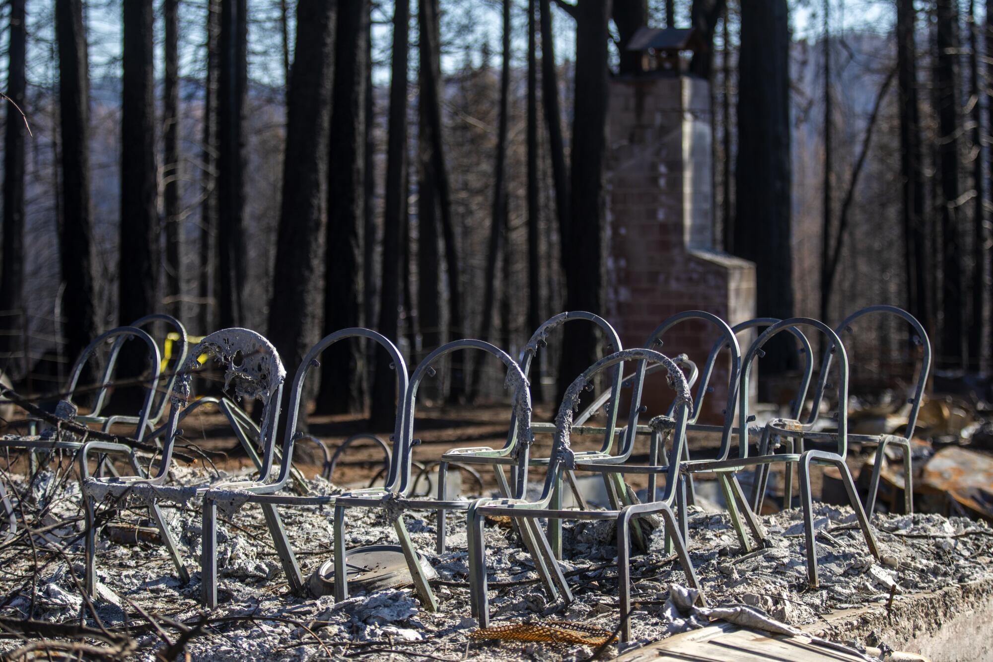 Metal chairs amid the burnt remnants of a church.
