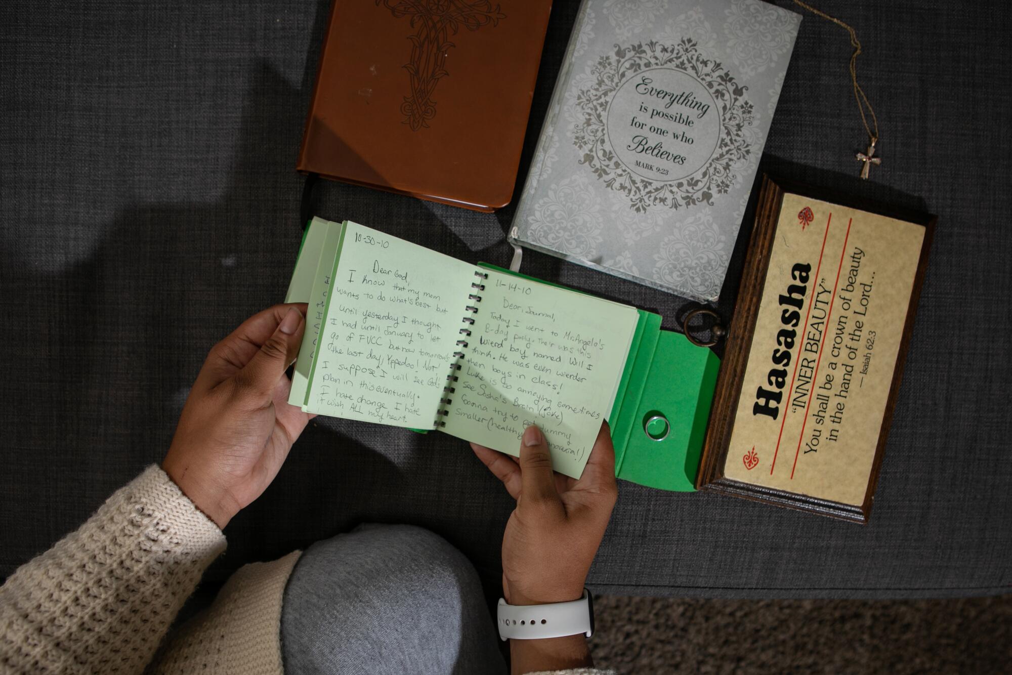 Hasasha Hasulube-George flips through a religious journal she kept as a girl 