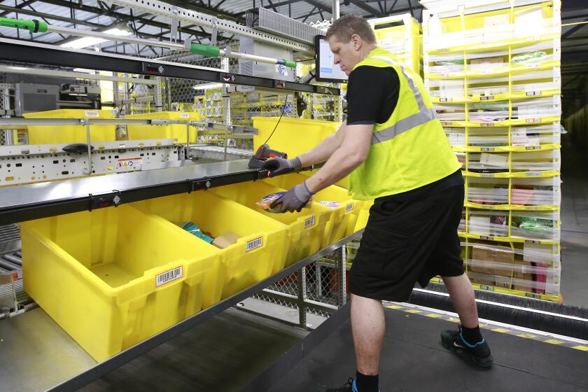 FILE - Merchandise is scanned to be tracked as it moves through the new Amazon Fulfillment Center in Sacramento, Calif., on Feb. 9, 2018. As global warming rises temperatures, a California labor protection board has approved standards, Thursday, March 21, 2024, that would require companies protect their employees from excessive heat even inside, particularly in warehouses. The rules still need final approval by the state's Occupational Safety and Health Administration. (AP Photo/Rich Pedroncelli, File)