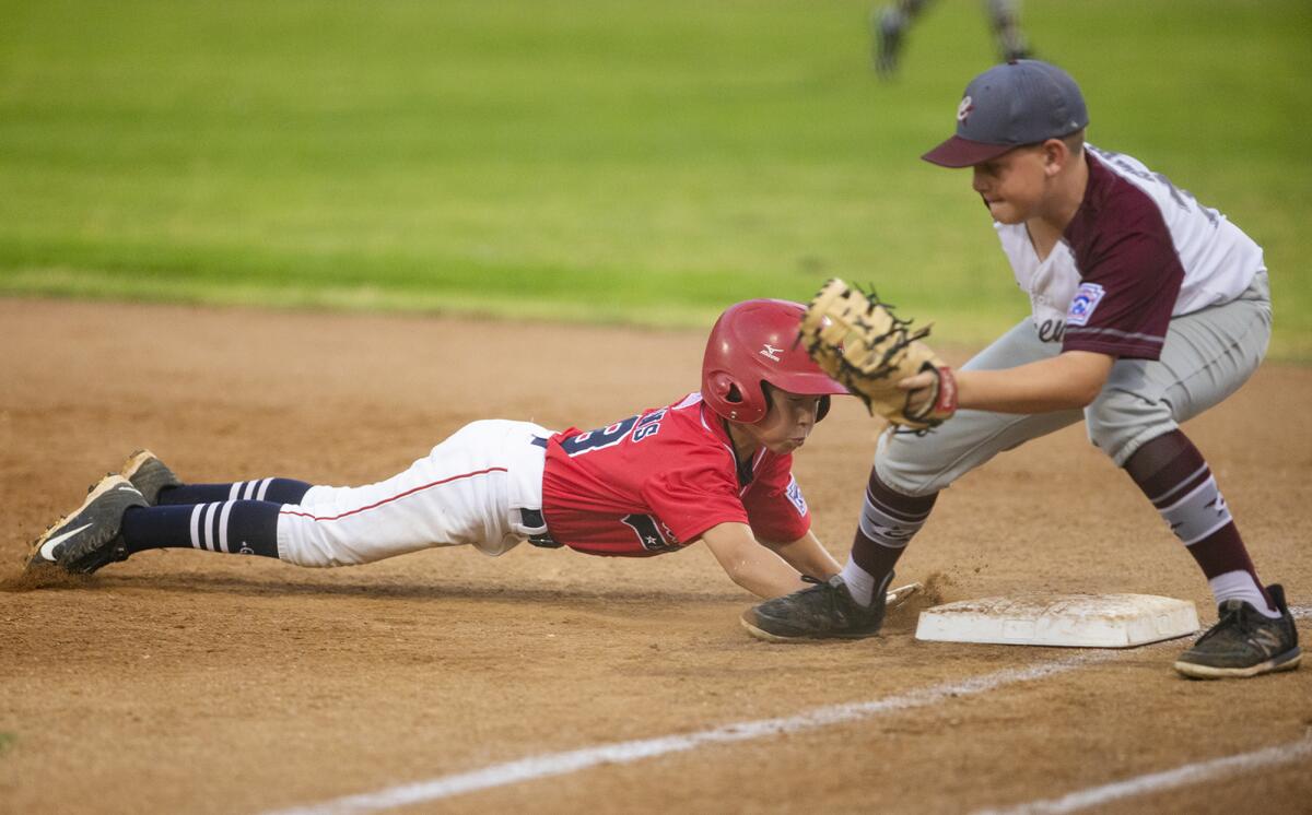 Ocean View Little League's Maxx Hopkins dives back to first base on a pick-off attempt by Claremont Little League's Lucas Roha in the Little League Southern California state tournament at Stearns Champions Park in Long Beach on Monday.