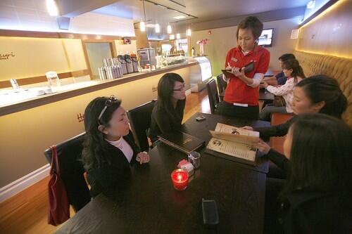Waitress Saem Choi takes orders from customers at Heyri Coffee House in Koreatown during their grand opening on Saturday night. As Korean immigrants become wealthier, more and more are investing in highend coffee shops in Koreatown.