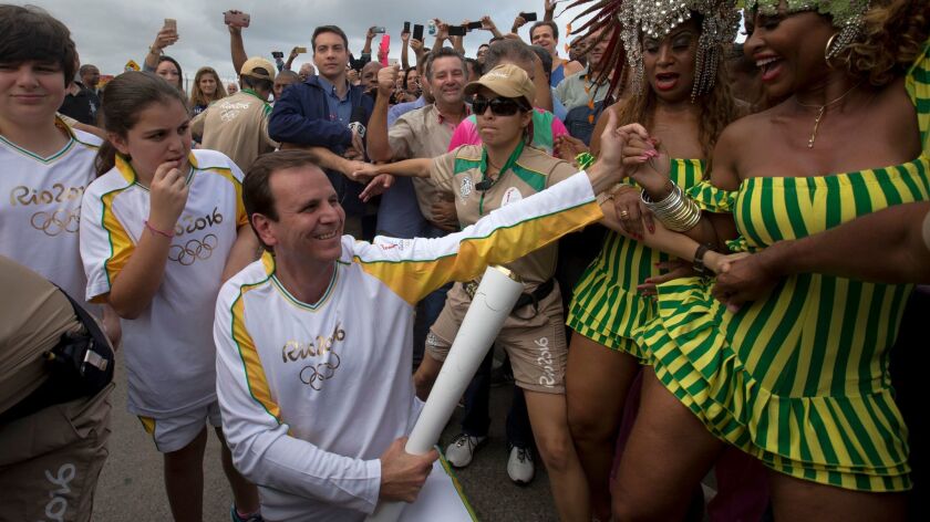 Then-Rio de Janeiro Mayor Eduardo Paes carries the Olympic torch on Aug. 3 prior to the 2016 Summer Olympics.