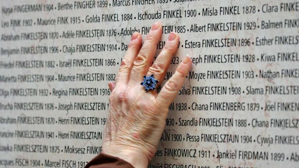 A hand touches the Wall of Names at the Shoah Memorial in Paris on Jan. 27, 2005.