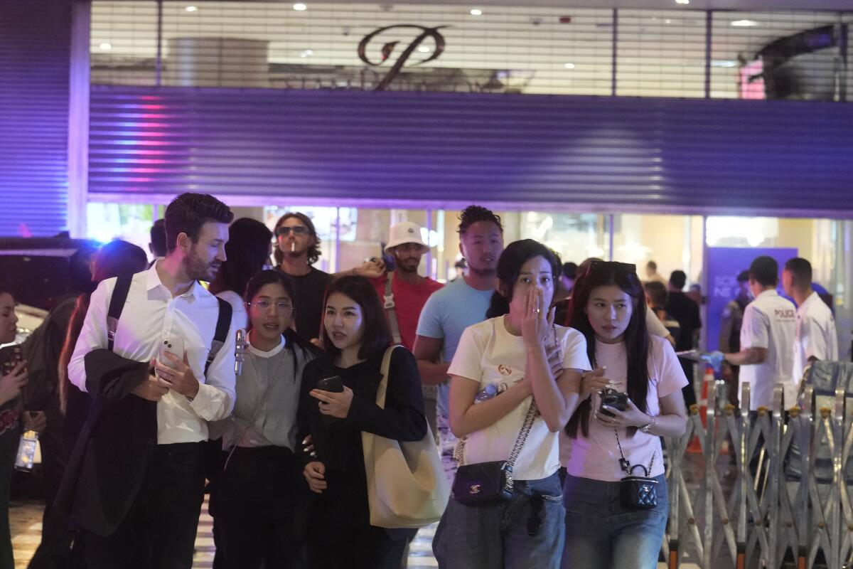 Shoppers evacuating from a mall in Bangkok because of a shooting