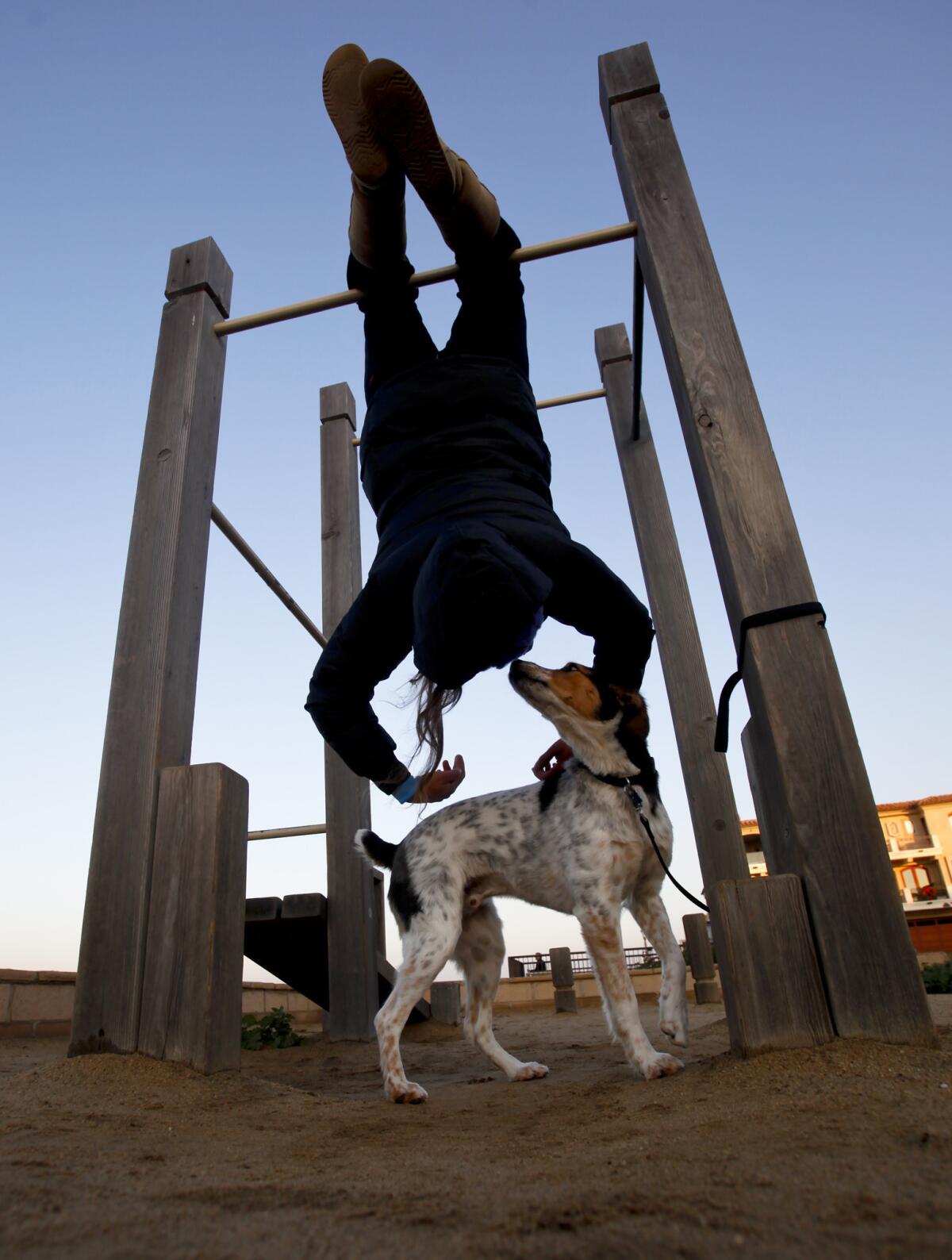 Karin Kendrick takes advantage of an outdoor gym in Manhattan Beach with her pal Lewy.