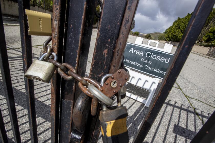 WOODLAND HILLS, CALIF. -- MONDAY, MARCH 23, 2020: Padlocks seal a gate for the Victory Trailhead at the Upper Las Virgenes Open Space Preserve, now closed to hiking in Woodland Hills, Calif., on March 23, 2020. (Brian van der Brug / Los Angeles Times)