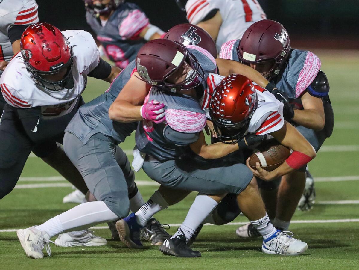 Laguna Beach middle linebacker Jeremy Kanter (22) sacks Westminster quarterback Alex Solano with a host of others on Friday.