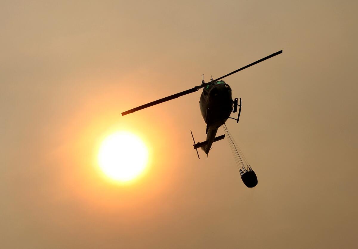 A California Department of Forestry and Fire Protection helicopter flies over Pfeiffer Ridge as a wildfire raged in the Big Sur area.