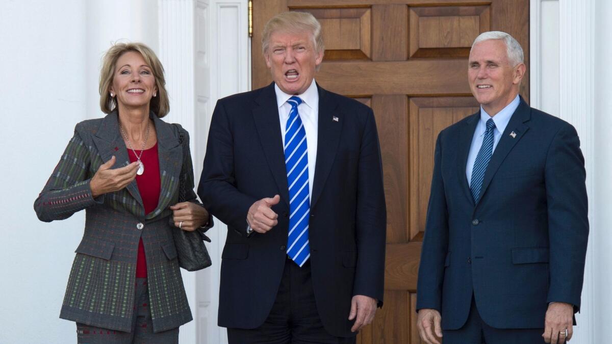 This November 19, 2016 photo shows US President-elect Donald Trump and Vice President-elect Mike Pence as they meet with businesswoman Betsy DeVos at Trump National Golf Club in Bedminster, New Jersey. Trump nominated DeVos to be his secretary of Education.