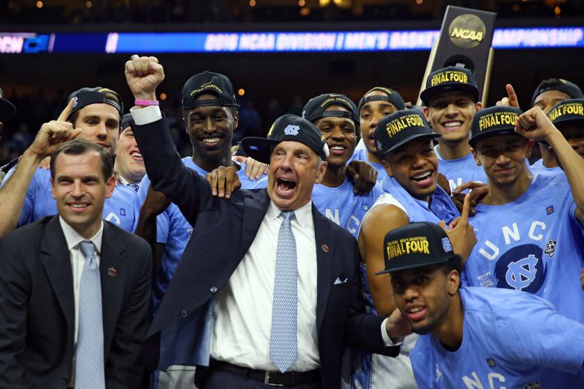 Coach Roy Williams celebrate with his North Carolina team after defeating Notre Dame in the East Regional final.