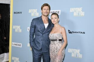 Actors Glen Powell, left, and Sydney Sweeney right embrace at the premiere of their film 