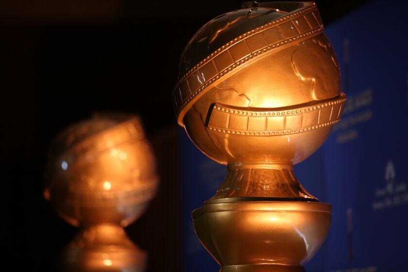 A closeup of two Golden Globe statuettes
