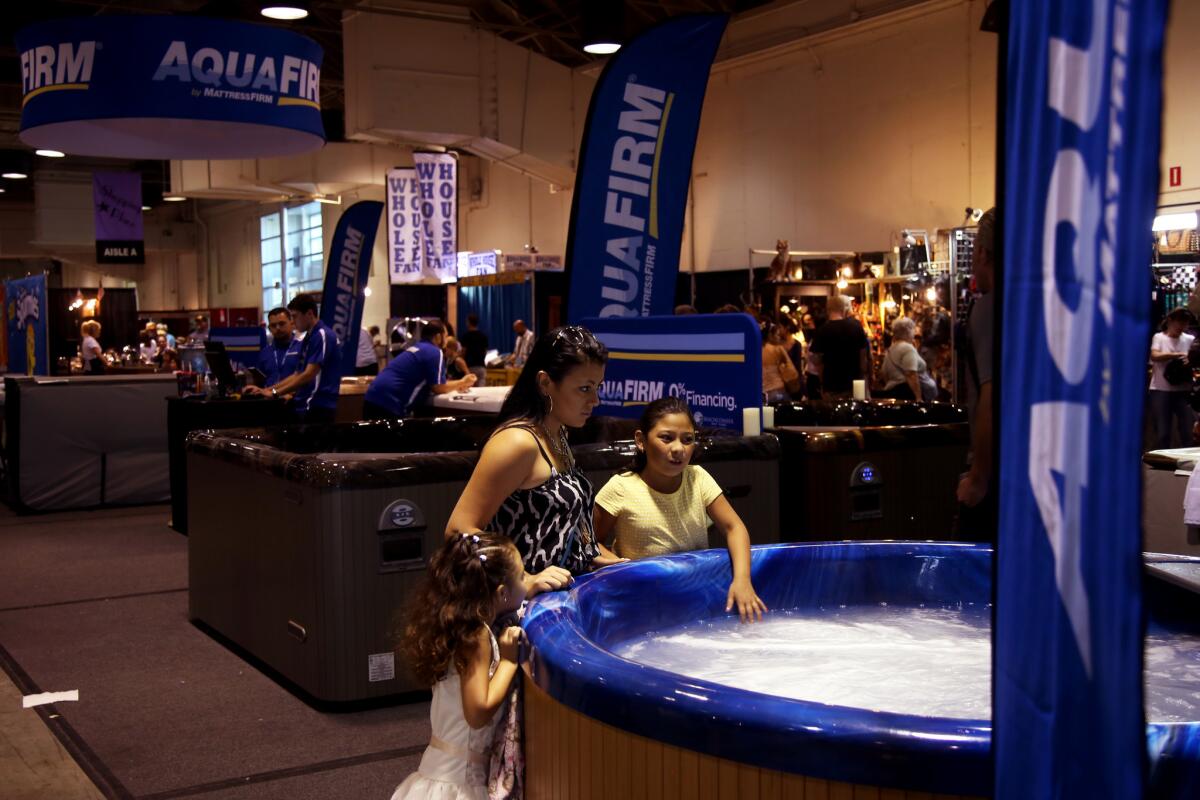 Fairgoers test the waters of a spa at the Los Angeles County Fair in Pomona. ( Rick Loomis / Los Angeles Times )
