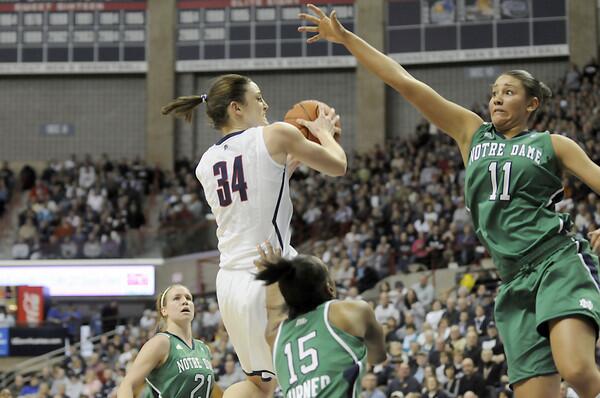 UConn's Kelly Fairs drives against Notre Dame's Natalie Achonwa and Kaila Turner.