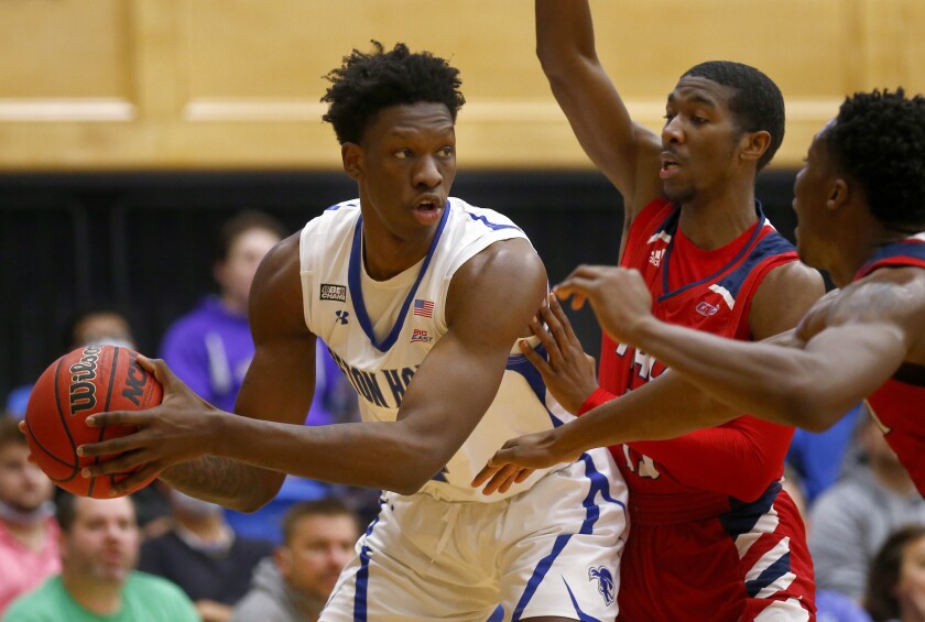Seton Hall forward Tyrese Samuel (4) is defended by Nyack College guard D'ondre Dent (13) and forward Isayas Aris (4) during the first half of an NCAA college basketball game on Saturday, Dec. 4, 2021, in South Orange, N.J. Seton Hall won 113-67. (AP Photo/John Munson)