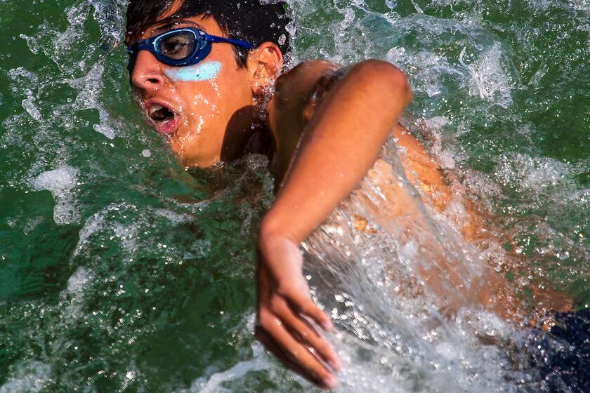 Los Angeles County Junior Lifeguard swims back to shore after jumping off the Hermosa Beach pier