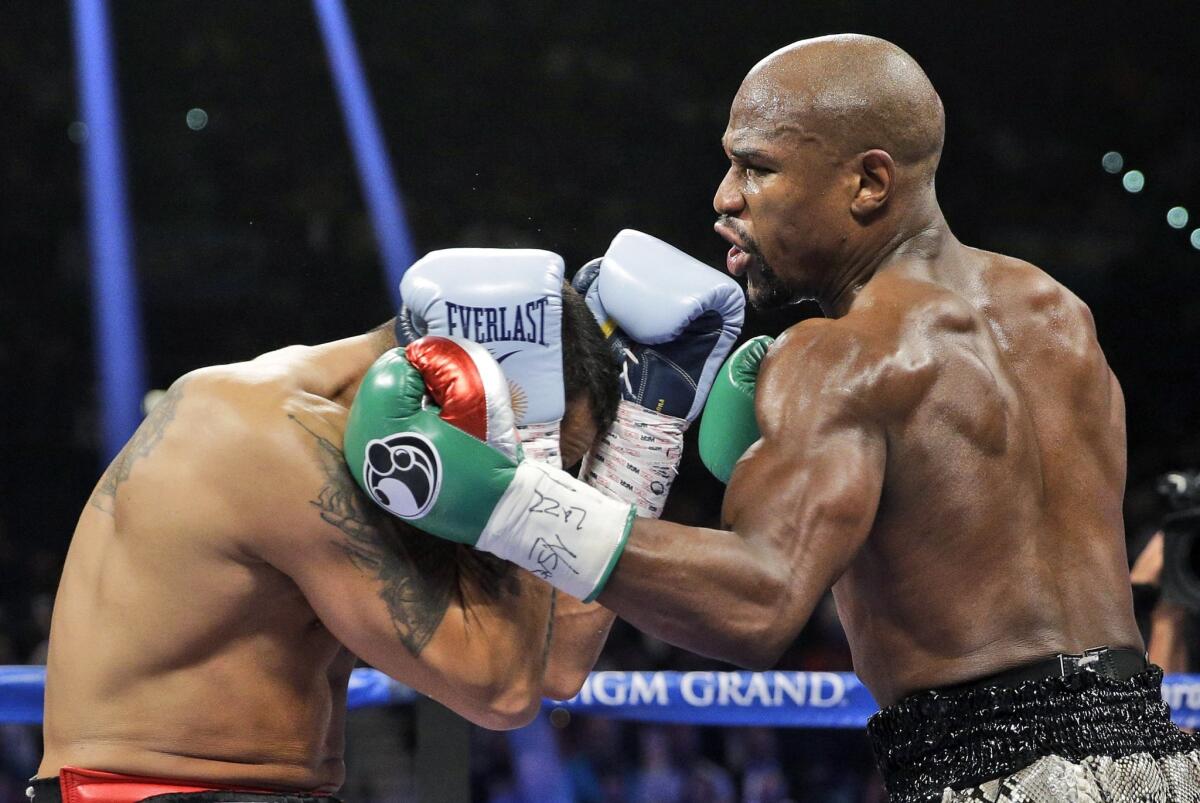 Floyd Mayweather Jr. lands a left hook against Marcos Maidana in their WBC/WBA welterweight title bout in Las Vegas.