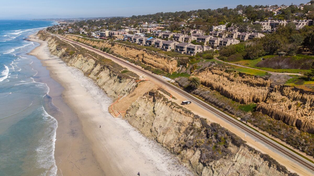 A cliff collapse next to a beach and houses