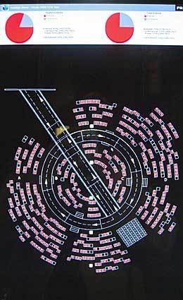 A computer display outside the Prada runway show shows the flow of the fashion show around the circular stage as well as attendee information scanned from bar codes.