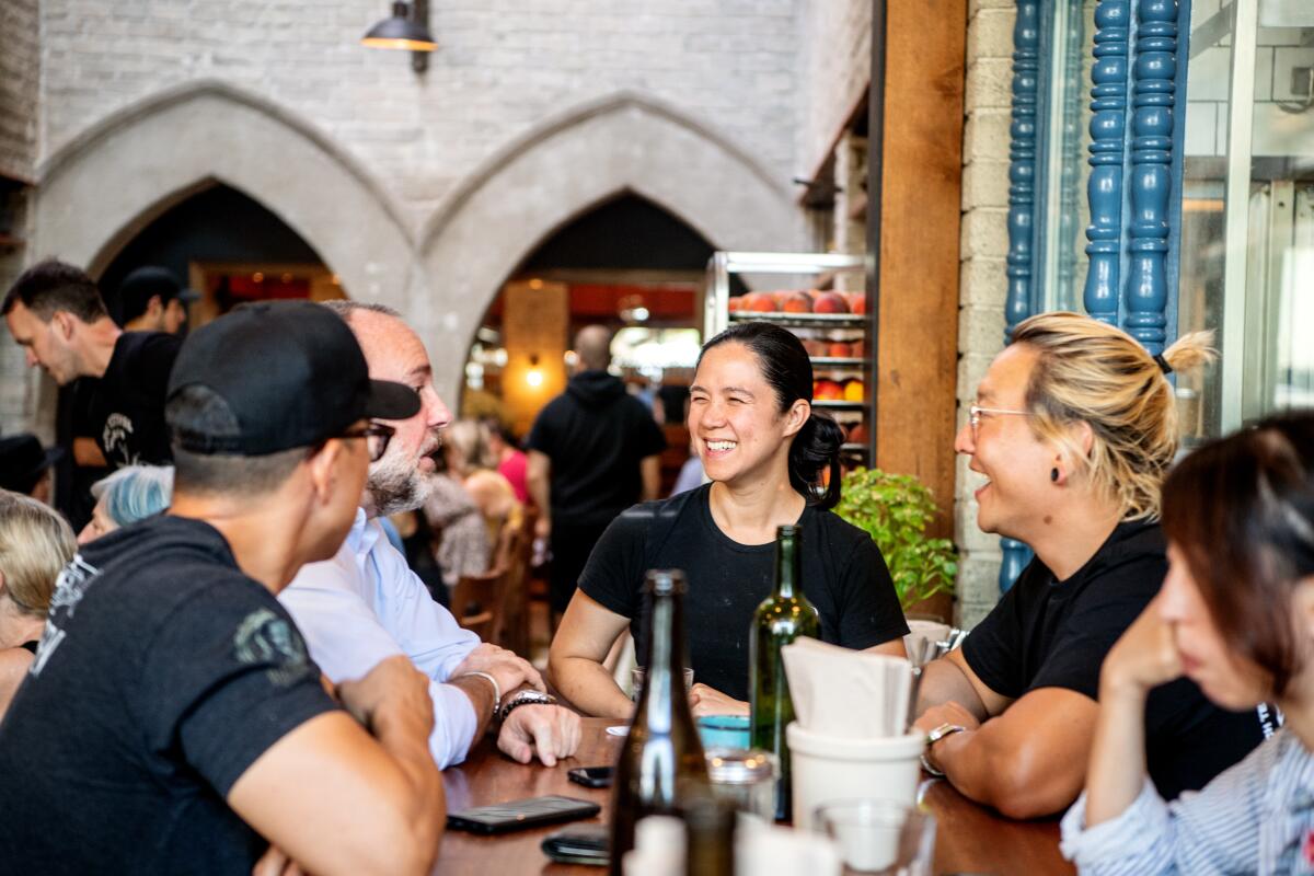 People in black T-shirts celebrating in a restaurant with pointed arches behind them