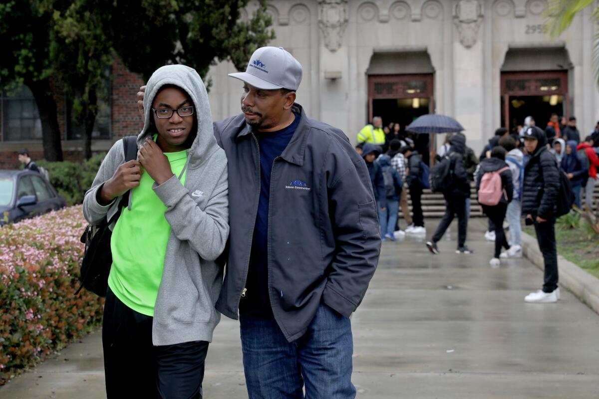 Blake Anderson, left, a freshman, walks with his father Oree Anderson, as school is let out at Hamilton High School in Los Angeles. LAUSD announced that schools will be closed due to the Coronavirus.
