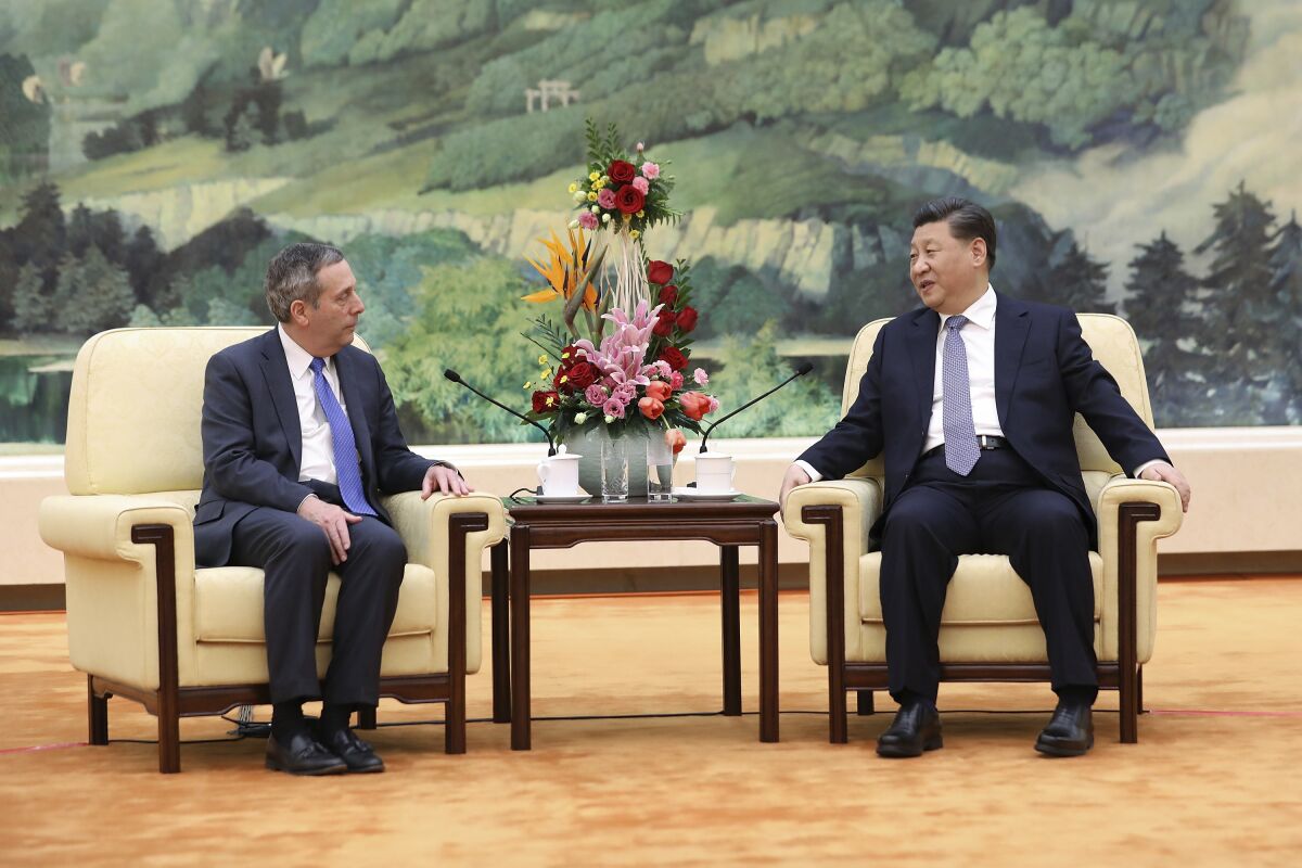FILE - In this March 20, 2019, file photo, Chinese President Xi Jinping, right, meets with Harvard University President Lawrence Bacow at the Great Hall of the People in Beijing. An intensive summer language program hosted by Harvard University in Beijing will relocate to Taiwan in summer of 2022, as the U.S.-China relationship remains strained. The program is moving to Taipei and will kick off next summer with about 60 students who will take eight weeks of classes, National Taiwan University confirmed Wednesday, Oct. 13, 2021. (Andrea Verdelli/Pool Photo via AP, File)