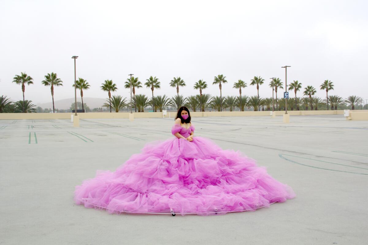Shay Rose in her pink, 12-foot wide-social distancing dress, in an empty parking lot at the Irvine Spectrum.