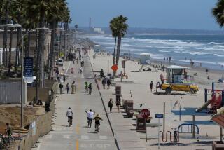 A smaller than normal May crowd is seen along The Strand and the beach in this view looking south from the Oceanside Pier on Wednesday, May 20, 2020 in Oceanside, California, USA. Vehicle traffic is limited to residents.