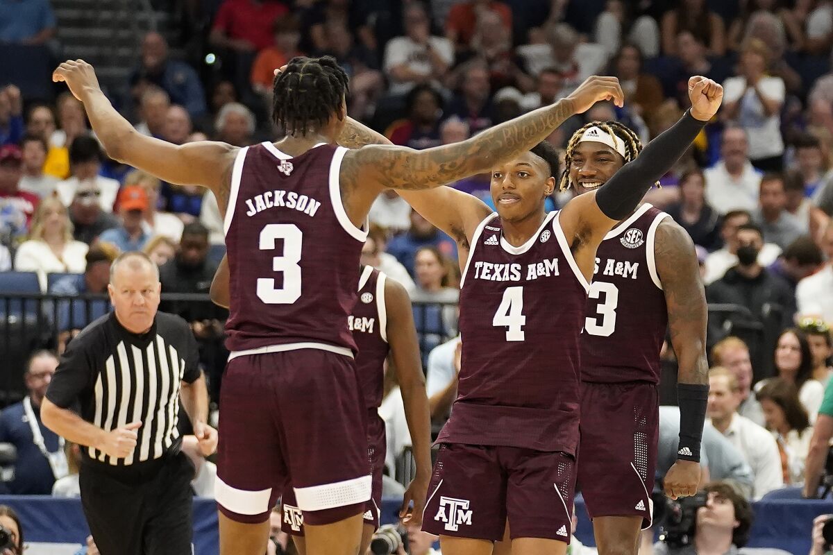 Texas A&M guard Wade Taylor IV (4) celebrates with guard Quenton Jackson (3) after the team defeated Auburn during an NCAA men's college basketball Southeastern Conference tournament game Friday, March 11, 2022, in Tampa, Fla. (AP Photo/Chris O'Meara)