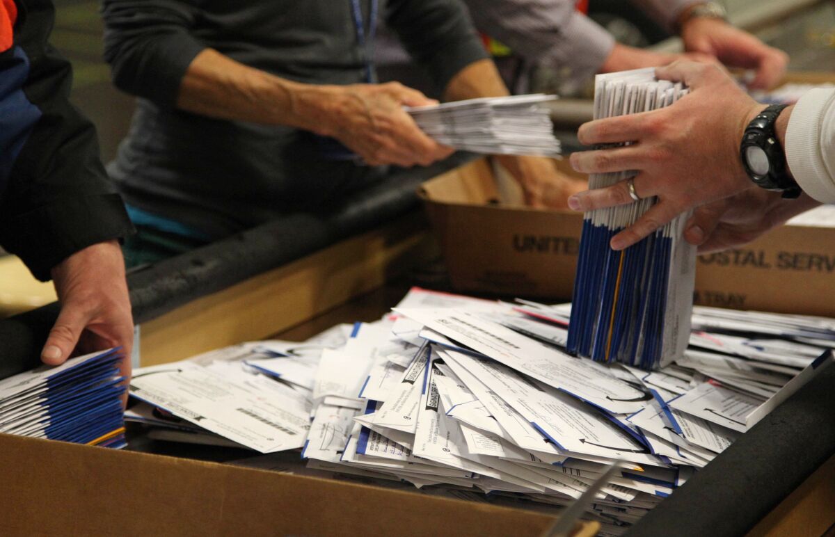 Election workers sort ballots at the Multnomah County Elections Office in Portland, Ore. A statewide measure to label genetically modified foods was still too close to call.