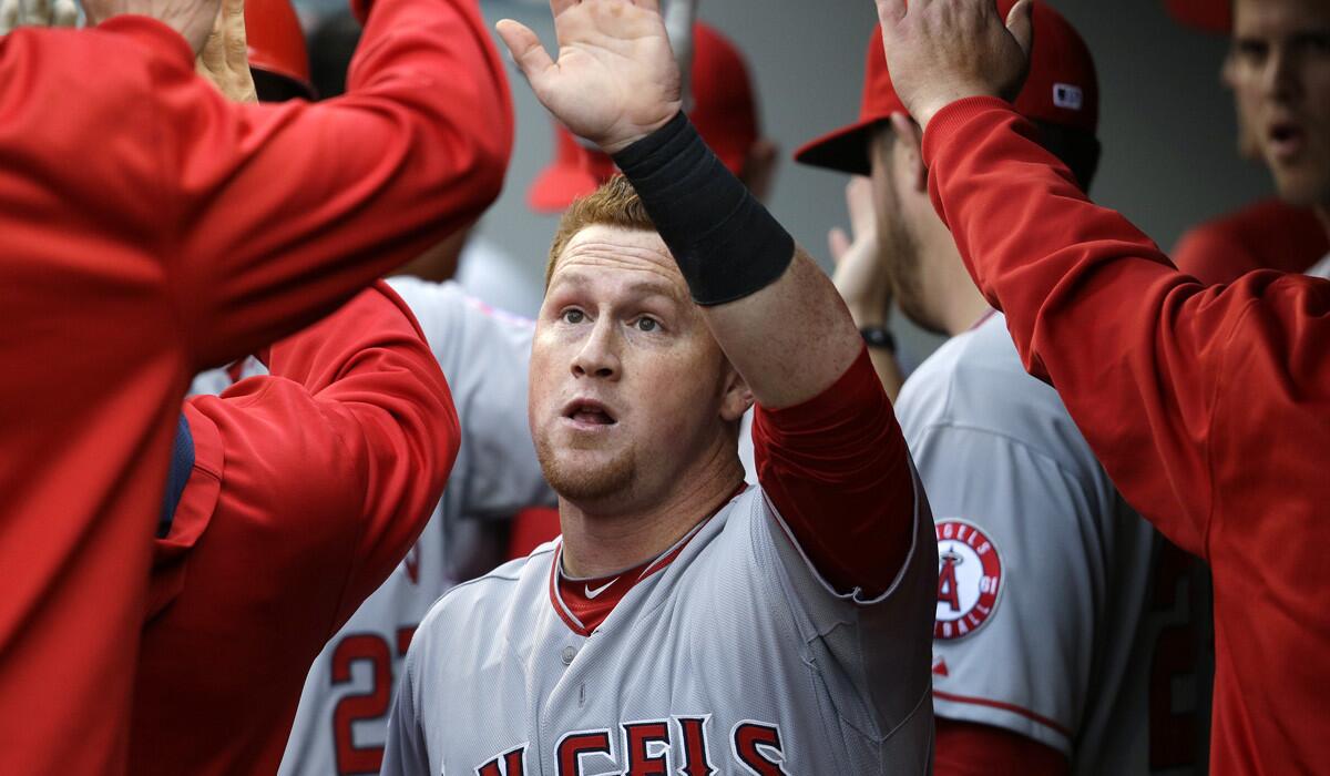 Angels right fielder Kole Calhoun is congratulated by teammates after scoring against the Seattle Mariners in the first inning Thursday.