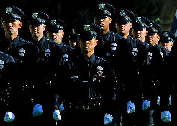 The latest graduates of the Los Angeles Police Academy wear black bands over their badges in honor of Marine Corps Reserve Sgt. Maj. Robert J. Cottle, the Los Angeles Police Department's first officer to be killed in combat in Afghanistan. Cottle, a SWAT officer, died Wednesday.