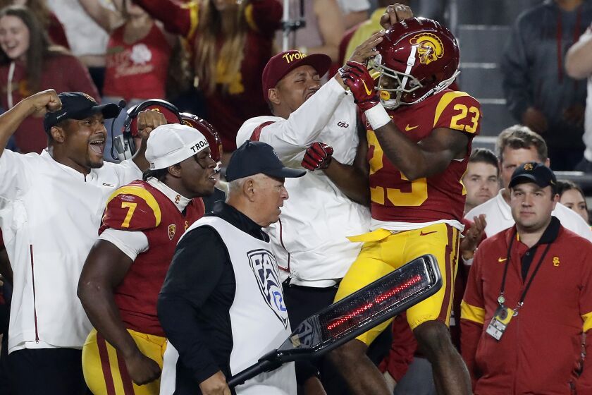 USC running back Kenan Christon (23) celebrates on the sideline after scoring a touchdown against Arizona in the fourth quarter Saturday night at the Coliseum.