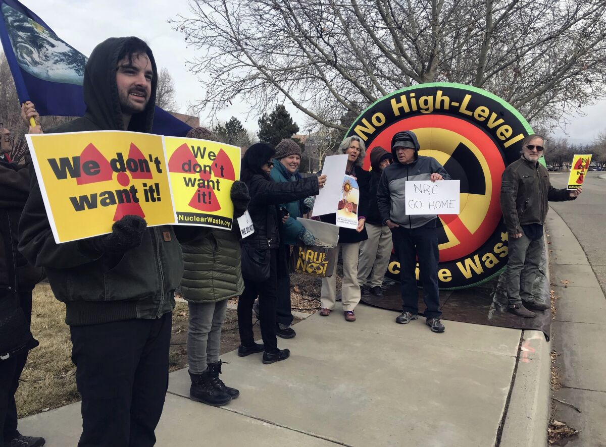FILE - Brendan Shaughnessy, left, with the Nuclear Issues Study Group, protests with other activists ahead of a meeting of a U.S. Nuclear Regulatory Commission panel in Albuquerque, N.M., on Tuesday, Jan. 22, 2019. Lawmakers have endorsed a measure that calls for banning the storage of spent nuclear fuel in N.M., unless the state provides its consent first. Democratic lawmakers have been raising concerns that opening the door to waste from commercial nuclear power plants around the U.S. would result in New Mexico becoming the nation's dumping ground. The legislation passed the House on Friday, March 17, 2023, and governor intends to sign it. (AP Photo/Susan Montoya Bryan, File)