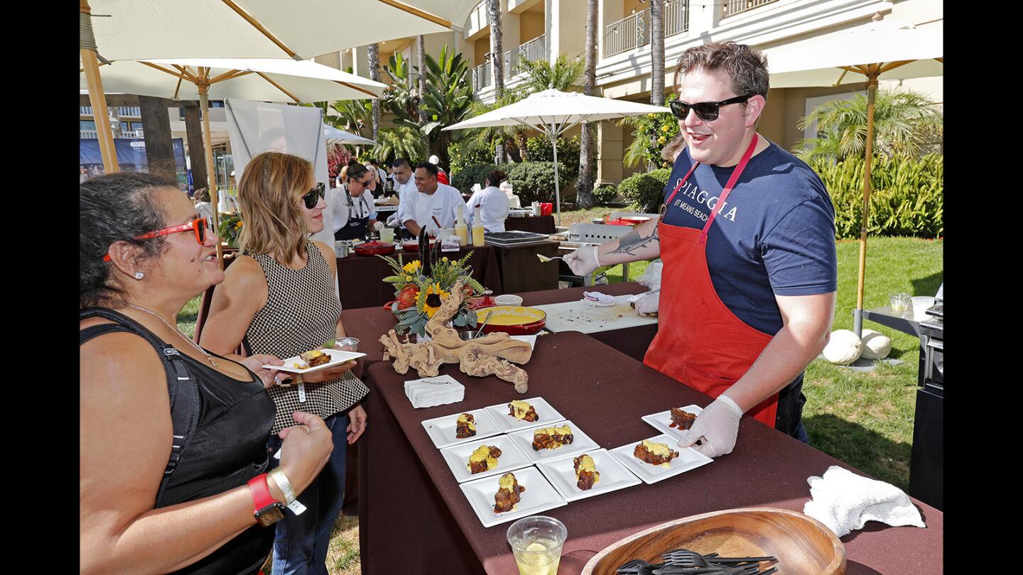 Chef Joe Flamm, right, of Spiaggia, winner of Season 15 of Bravo's "Top Chef," talks with Vanna Arbuckle, second from left, and Jael Tahti, left, on Friday at the Balboa Bay Resort during the fifth annual Newport Beach Wine & Food festival.