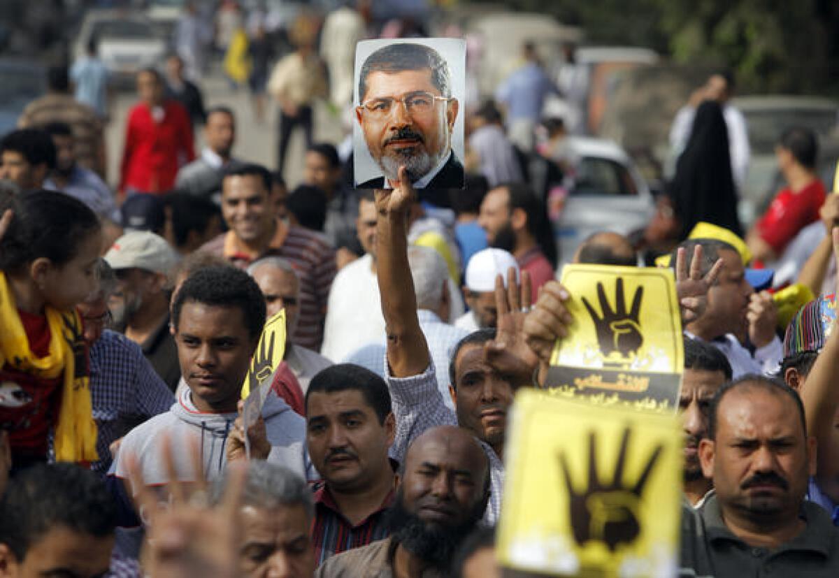 Supporters of Egypt's Mohamed Morsi raise the ousted president's image at a protest last week in Cairo.