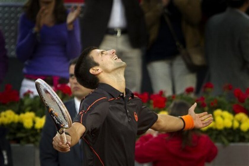 Novak Djokovic from Serbia celebrates after defeating Rafael Nadal from Spain following their singles final tennis match during the Madrid Open tennis tournament in Madrid, Sunday, May 8, 2011. (AP Photo/Arturo Rodriguez)