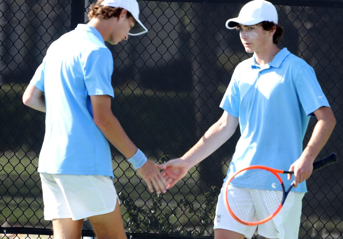 CdM's No. 1 doubles team of Jonathan Hinkel, left, and Roger Geng slap hands after winning a point on Friday.