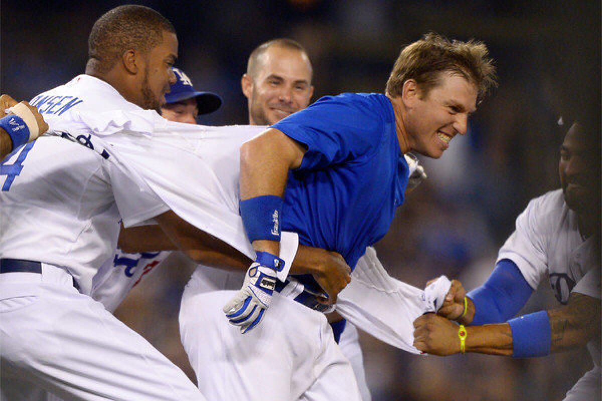Teammates rip the jersey off of A.J. Ellis after his game-winning RBI single in the bottom of the ninth inning of the Dodgers' 4-3 victory over Philadelphia.