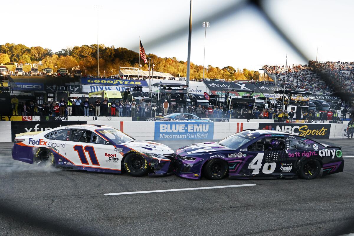 Denny Hamlin (11) prevents Alex Bowman (48) from doing a celebratory burnout after Bowman's win at Martinsville Speedway.