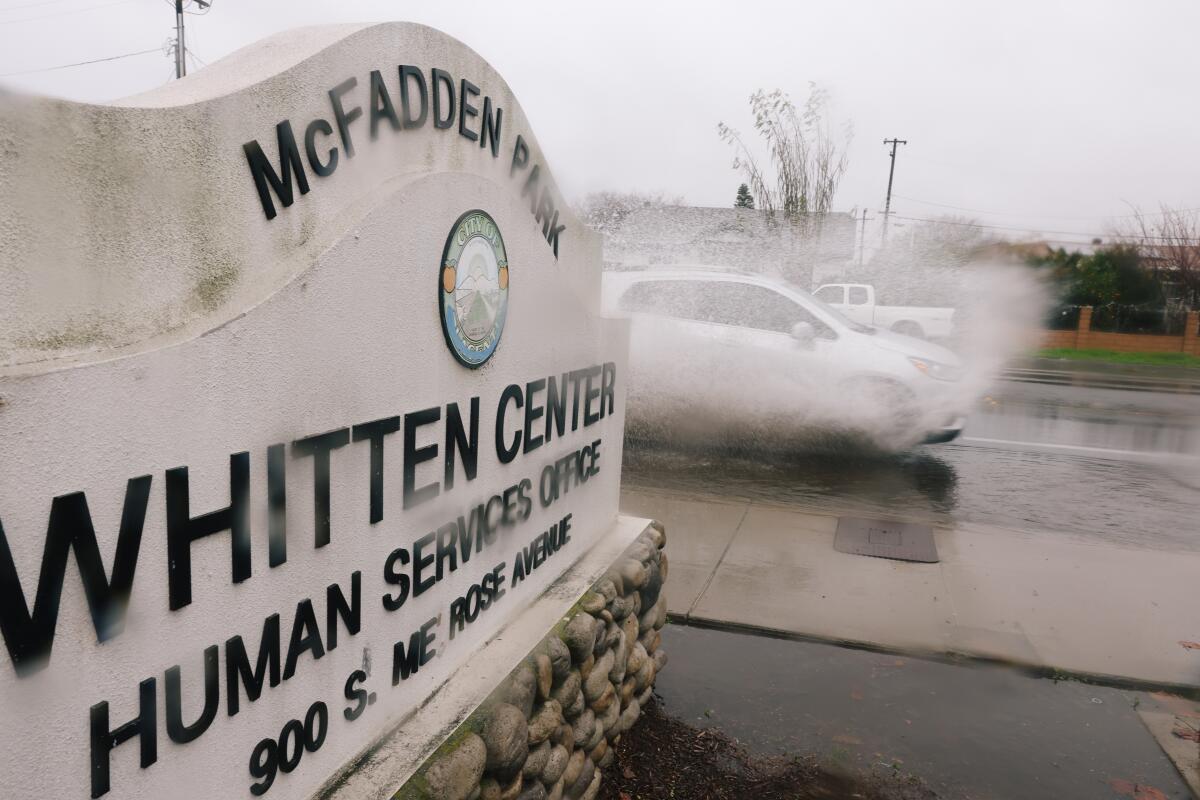 A car passes a sign for the Whitten Center at McFadden Park.