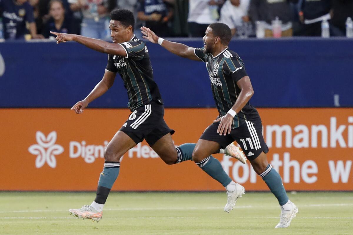 Galaxy midfielder Rayan Raveloson celebrates his goal against the Portland Timbers with midfielder Samuel Grandsir.