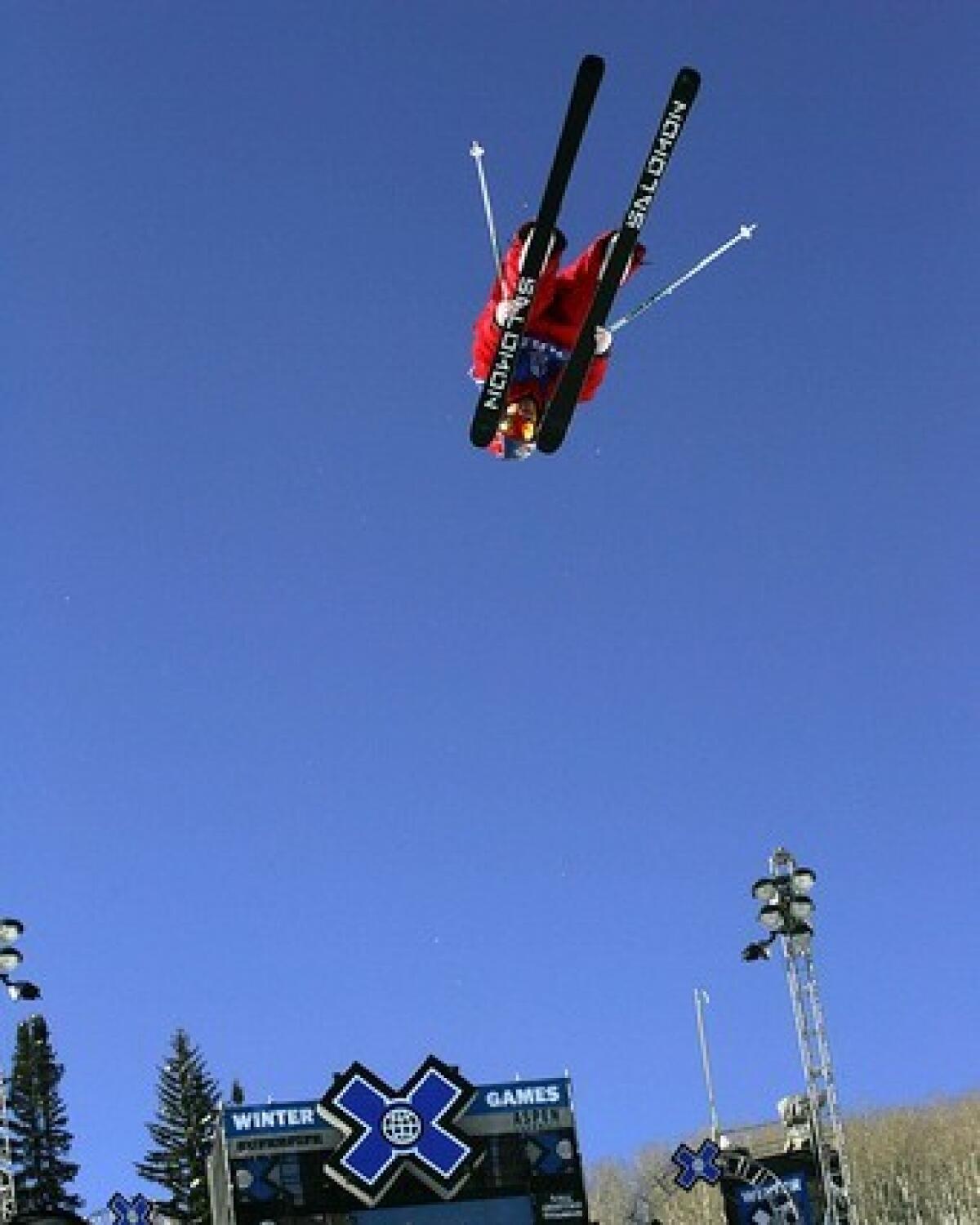 Simon Dumont of Bethel, Maine, flies in the air looking through his skis in the Skiing SuperPipe.