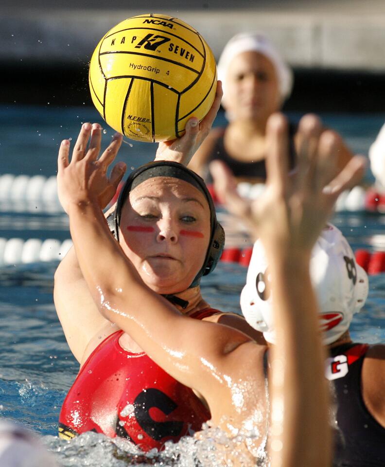 Burroughs' Emilee Holgate rises and takes a shot to score her team's first goal, despite the defense of Glendale's Rima Gasparian in the first quarter in a Pacific League girls water polo match at Burroughs High School in Burbank on Thursday, January 17, 2013.