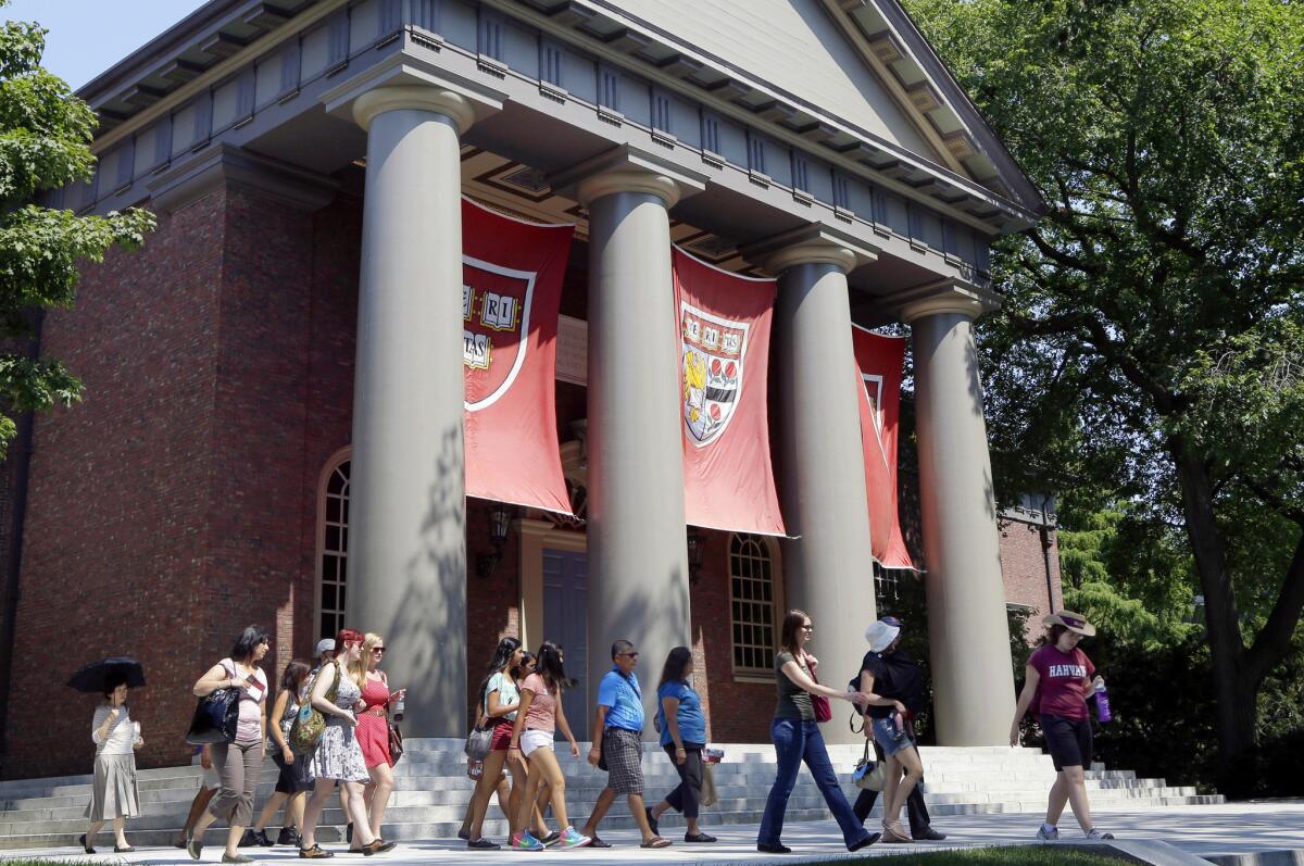 A tour group walks through the campus of Harvard University in Cambridge, Mass., on Aug. 30, 2012.