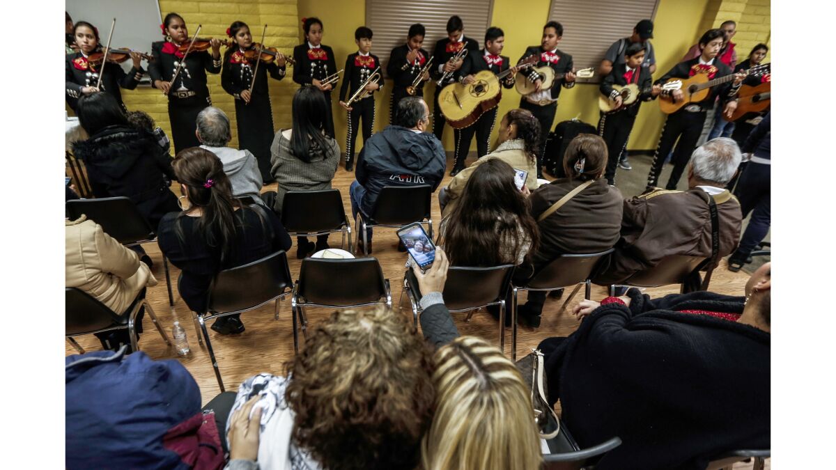 A youth mariachi band performs for a group of around 40 Mexican parents and their children after they were reunited in Paramount.