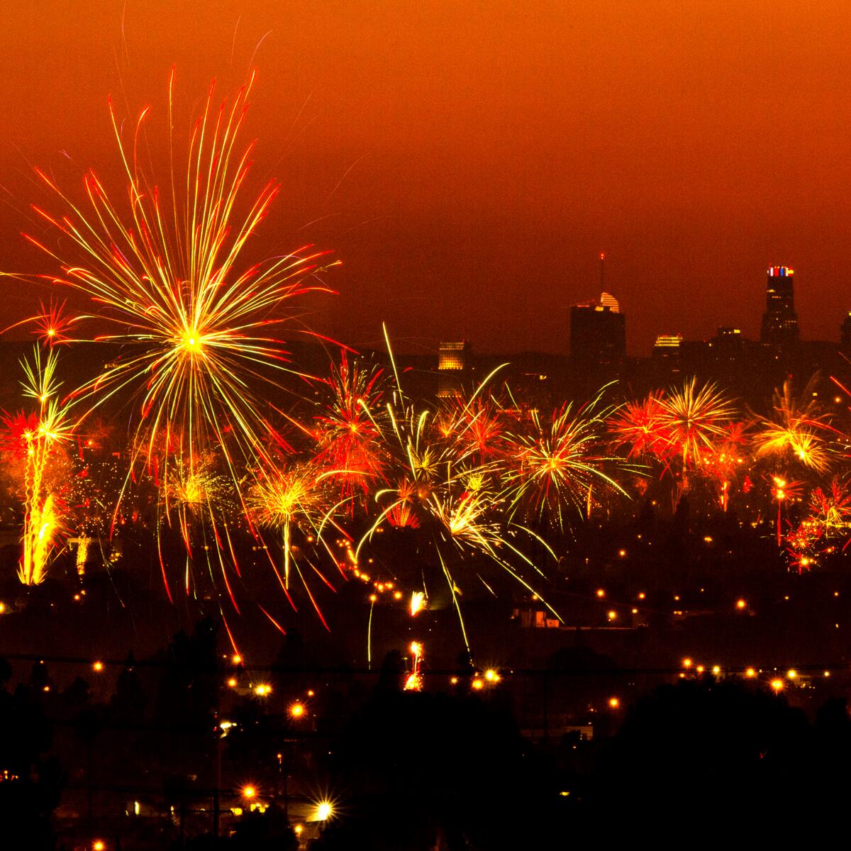  A dark Los Angeles skyline can be seen behind the exploding fireworks.